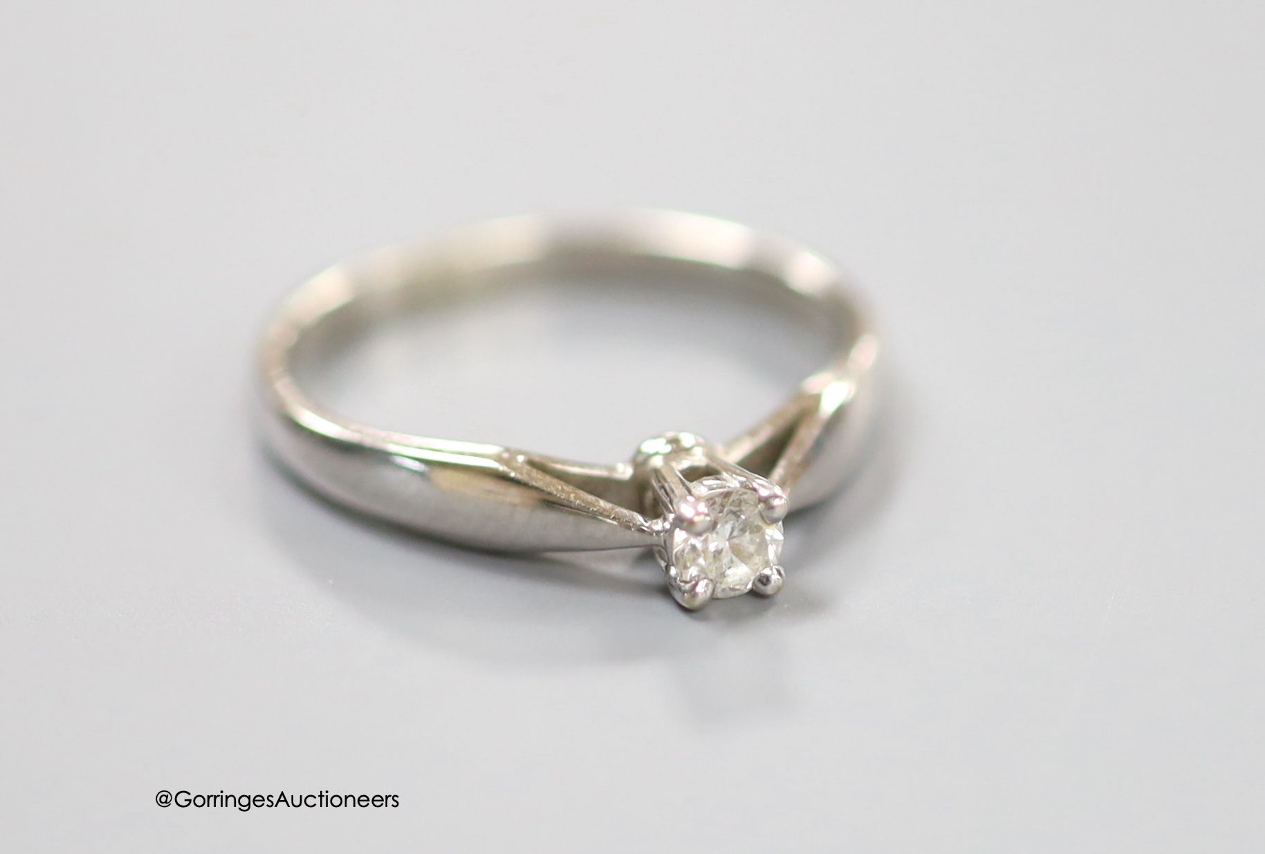 A modern 14ct white gold and solitaire diamond set ring, the stone weighing 0.15ct, size L, gross weight 2.1 grams.